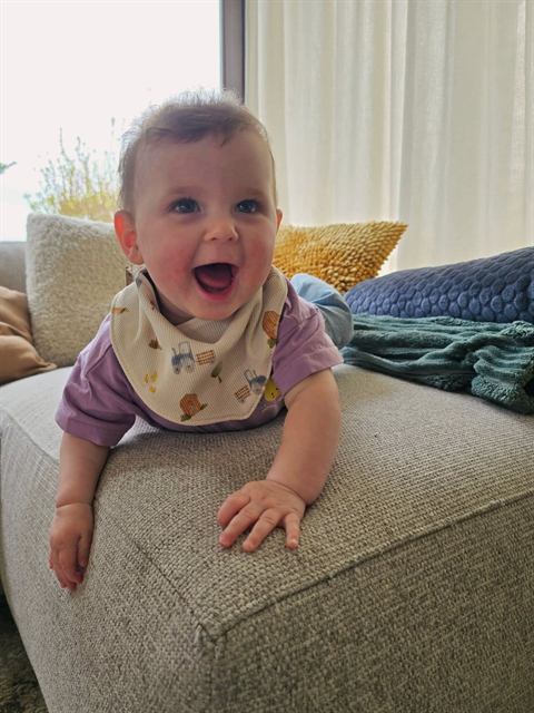 Lachende baby met slabbetje